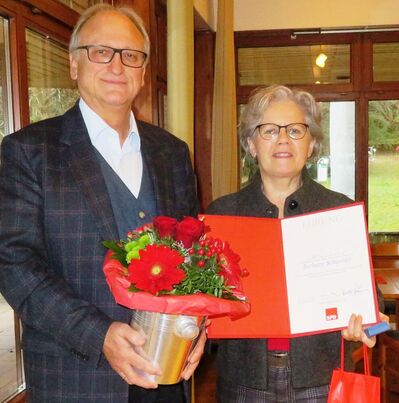 Hanspeter Hauke ehrte Barbara Schweizer für 25 Jahre SPD-Mitgliedschaft mit Brosche, Urkunde, Wein und Blumen. Foto: Eva